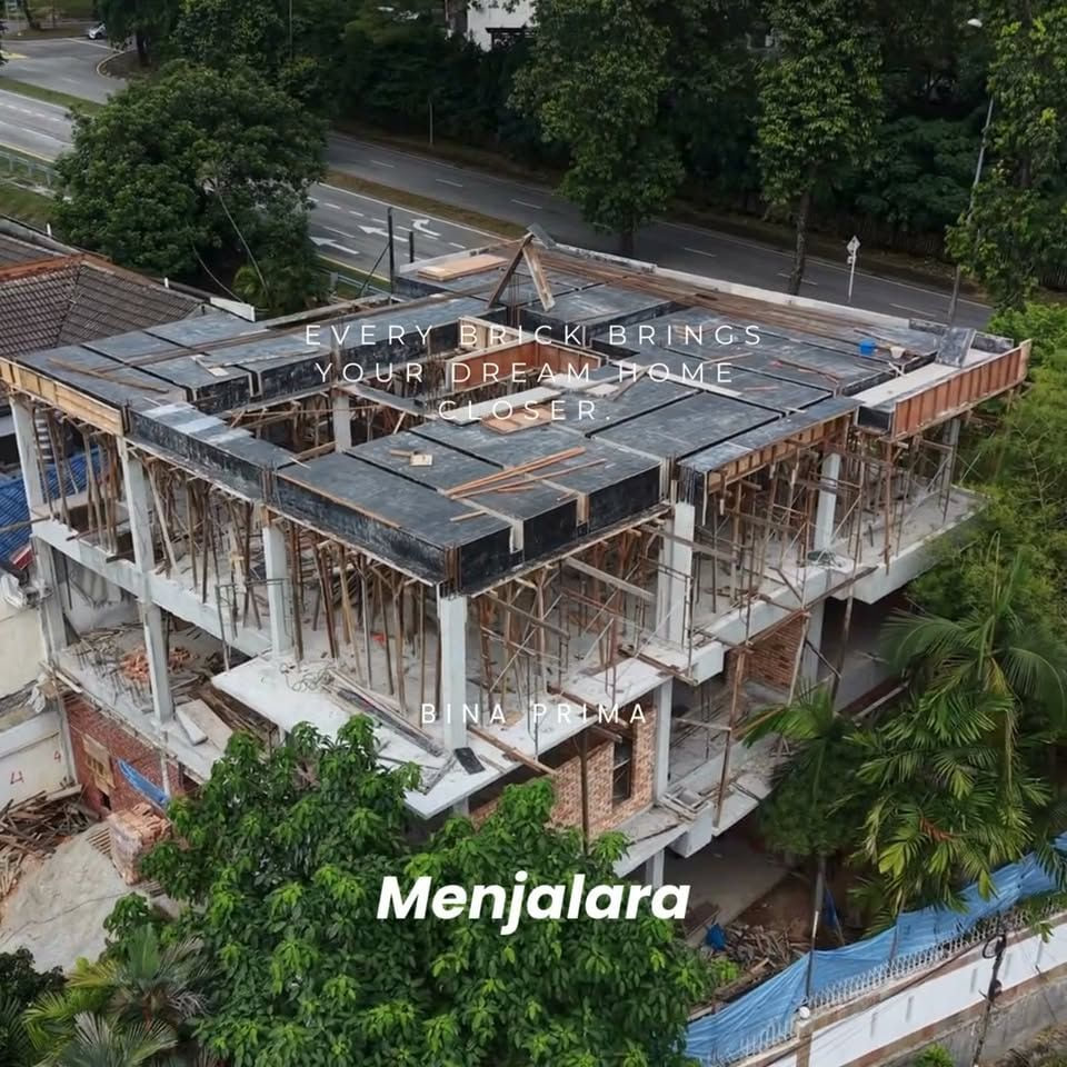 A drone view of a large two-storey house under construction: a cast concrete frame with timber formwork and props, a waterproofed slab and a timber roof-truss apex, captioned "Every brick brings your dream home closer", "BINA PRIMA" and "Menjalara".